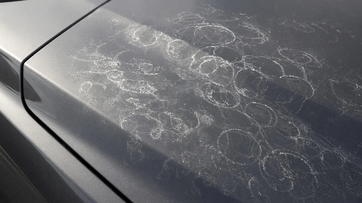 Dried water spot rings left on dark gray car paint